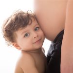 Enfant écoute le ventre de sa maman, séance photo grossesse en Essonne (91)