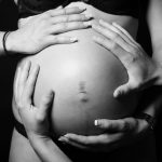 Photo en noir et blanc des mains de la famille pour photo de grossesse dans le 77