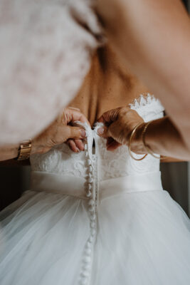 fermeture de la robe de la mariée par la maman couleur d'automne