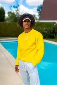 modèle photo homme avec pull jaune devant piscine